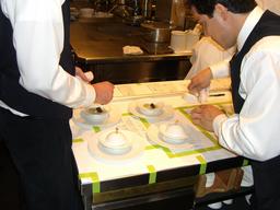 Photo of a cook placing the lids on the oysters and pearls dish